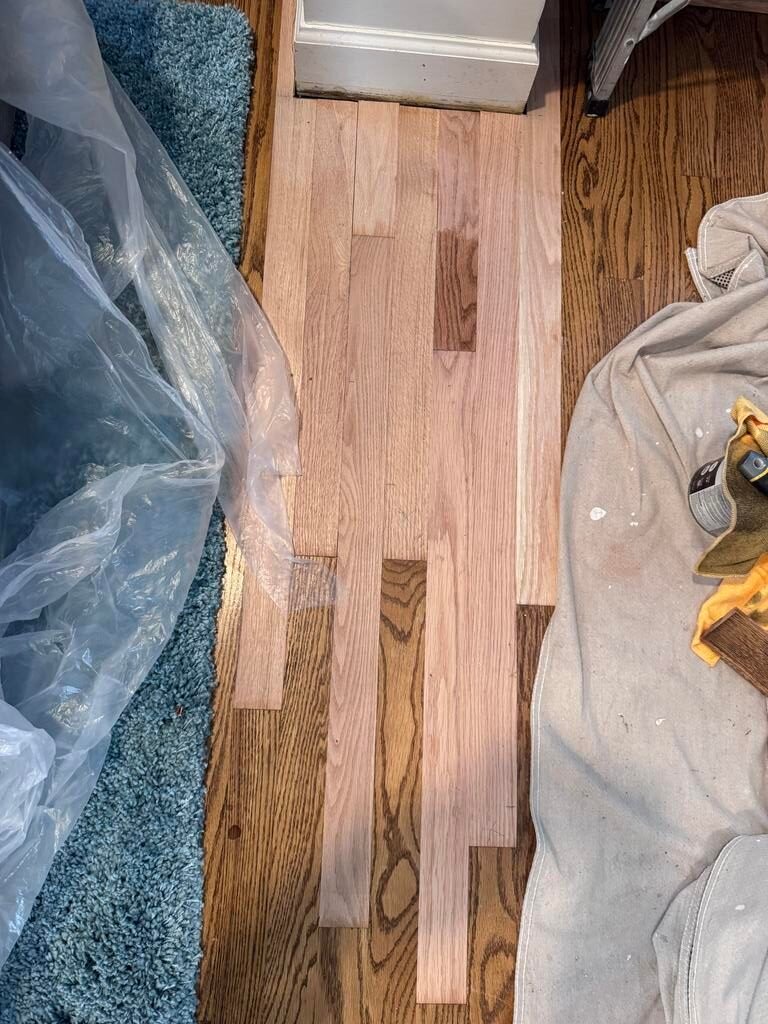 Hardwood floor with column bases before repair in Arlington, VA